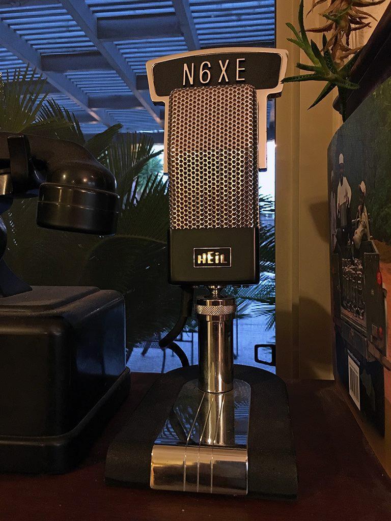 A retro-looking Heil ham radio microphone in chrome and black, with a custom callsign flag at the top.