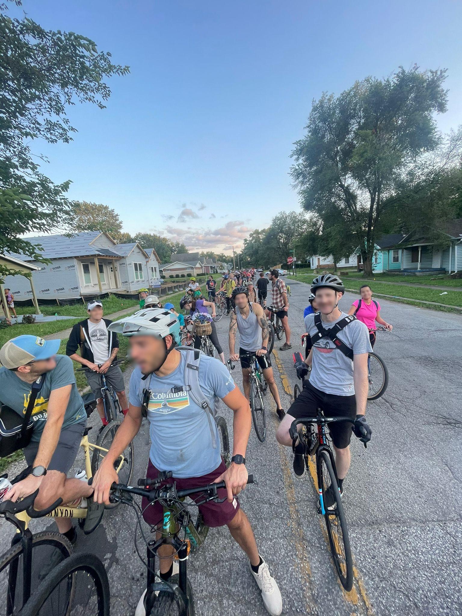 A bunch of people on bicycles stopped at an intersection.