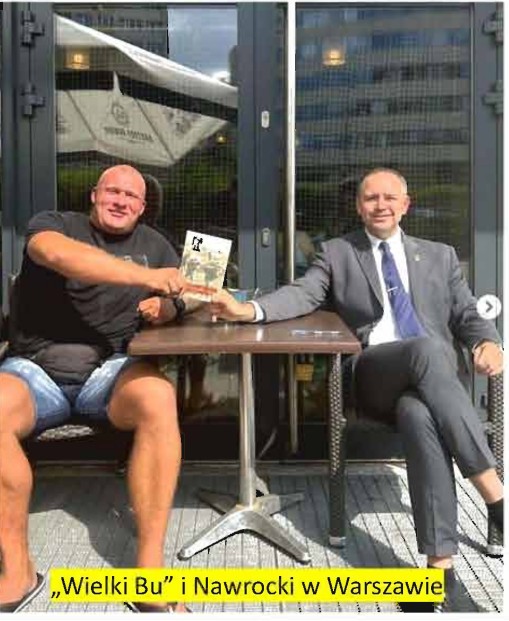 Na zdjęciu dwóch okrągłogłowych: jeden barczysty w szortach i t-shircie, drugi w garniturze pod krawatem. W kawiarnianym ogródku pozują do zdjęcia z niewyraźnie widoczną książeczką. Podpis: "Wielki Bu" i Nawrocki w Warszawie.